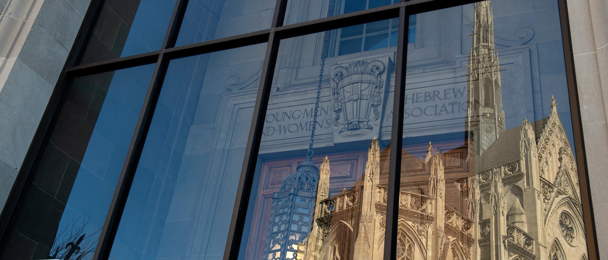reflection of the Cathedral of Learning in a window